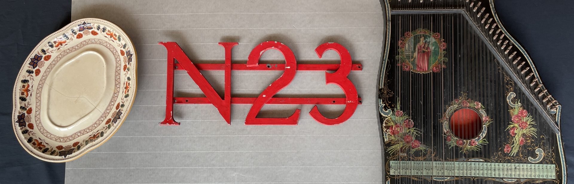 L-R, the plate of a Wedgwood soup tureen; the N23 sign from the Heidelberg West Post Office; a German-made zither, probably from before World War 1.