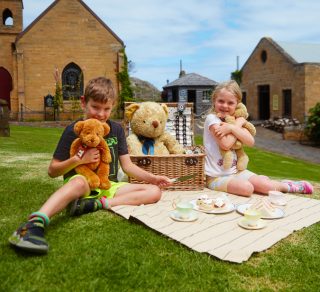 Children enjoying a picnic with their teddies in the village related image