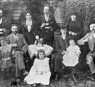 Tea was often served in the garden if the family had one This photograph shows the Stewart Family at Warracknabeal c 1900s Here even quite small children have cups while the table is covered with a fringed tea cloth embellished with extensive drawn thread work The tea kettle or large teapot may be resting on a small primus stove to keep the brew hot related image