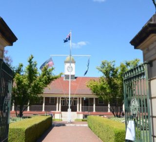 Photograph of the Administration Block formerly the original 1925 classroom block through the original Mint Gates that once stood at the Mint in Sydney related image