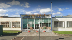 A long white building in International Modern Movement style, with a blue sign saying 'James Nelson (Tas) pty ltd
