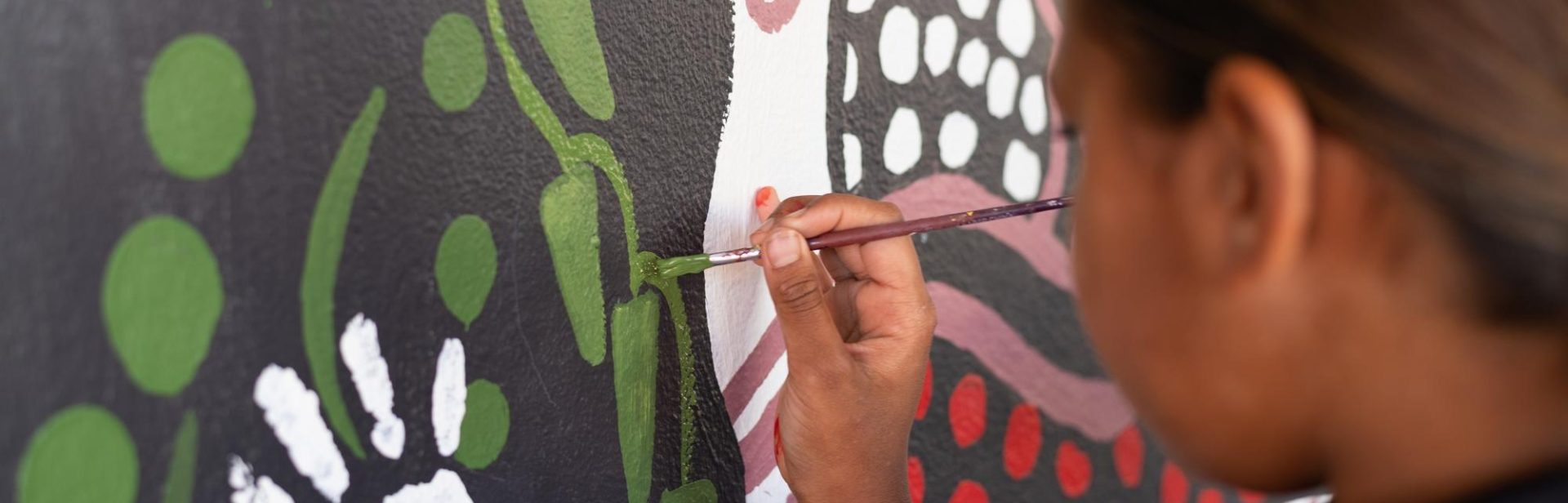 Young child painting a mural